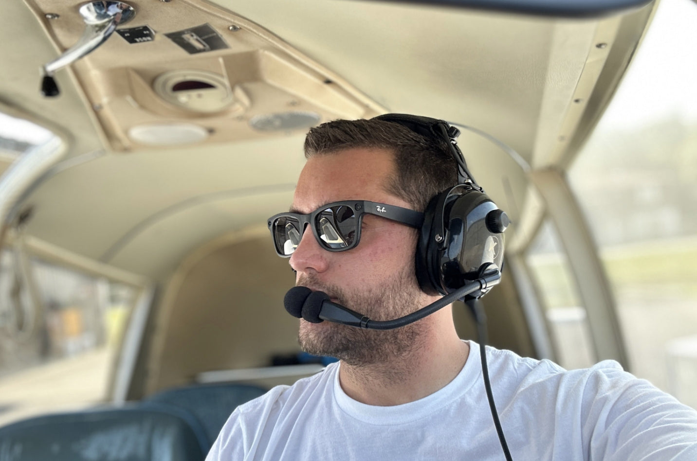 Young student pilot wearing an aviation headset and smiling during preflight checklist
