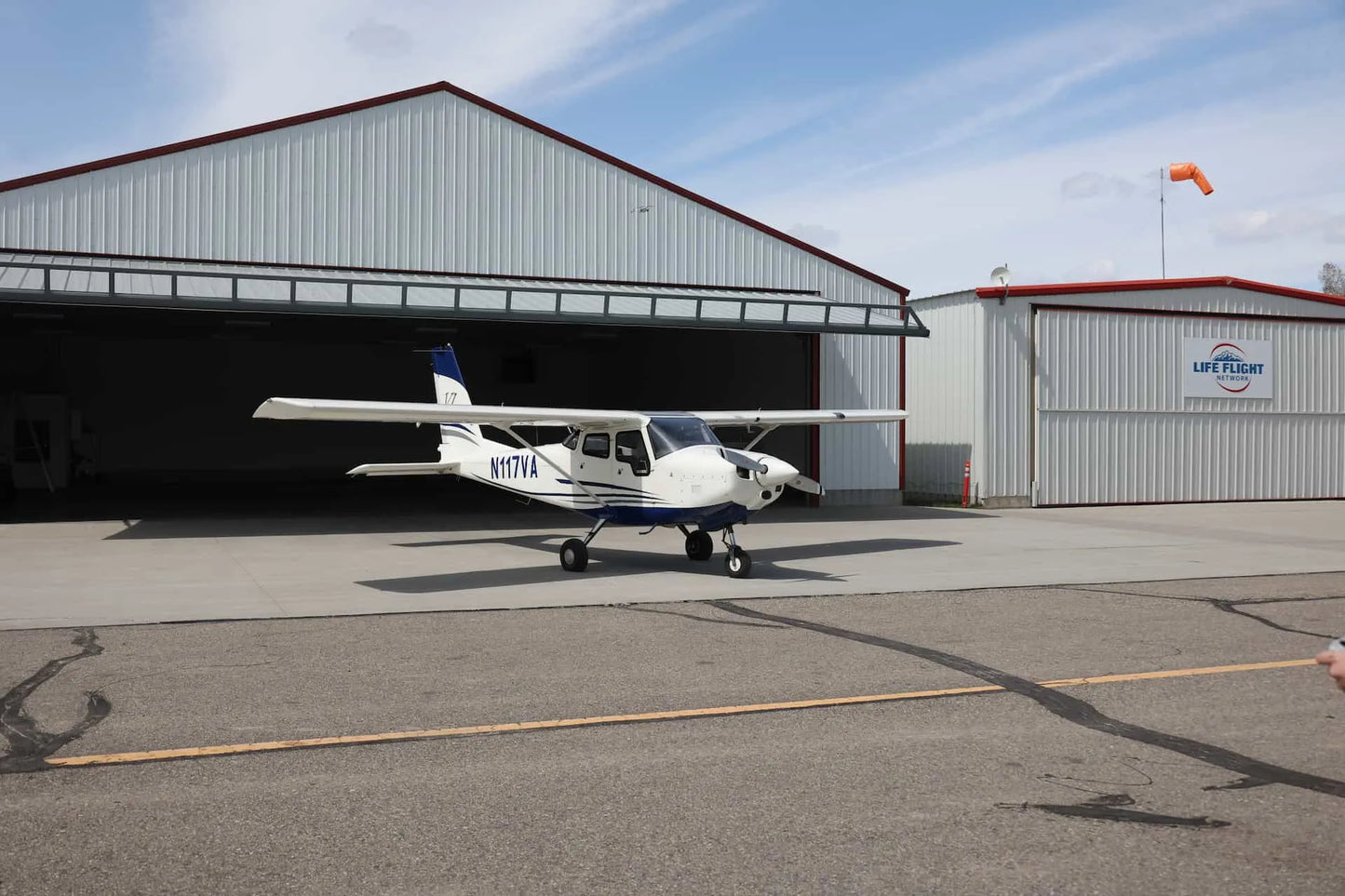 Student pilot studying with headset comparing Part 61 vs Part 141 flight training options in a flight school office